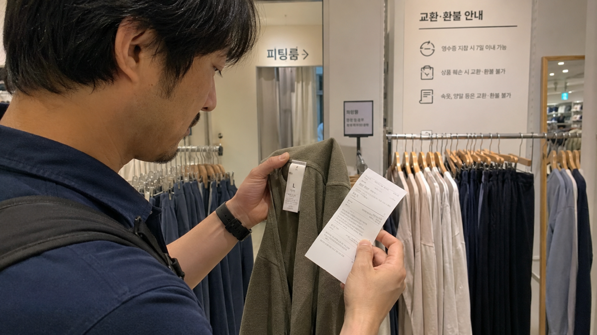 韓国の店で服のタグとレシートを確認