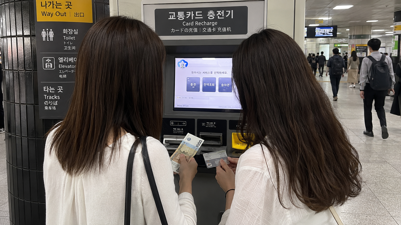 地下鉄駅でT-moneyを現金チャージする女性